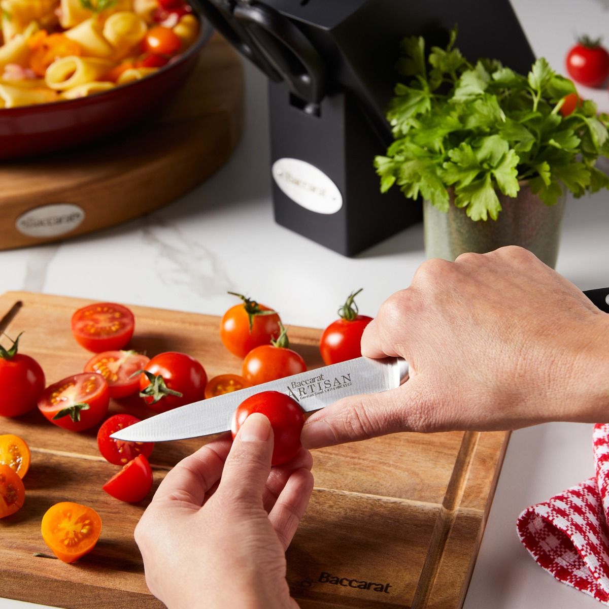 Top view of Baccarat Artisan Finster kitchen knives featuring sleek black handles on a wooden board