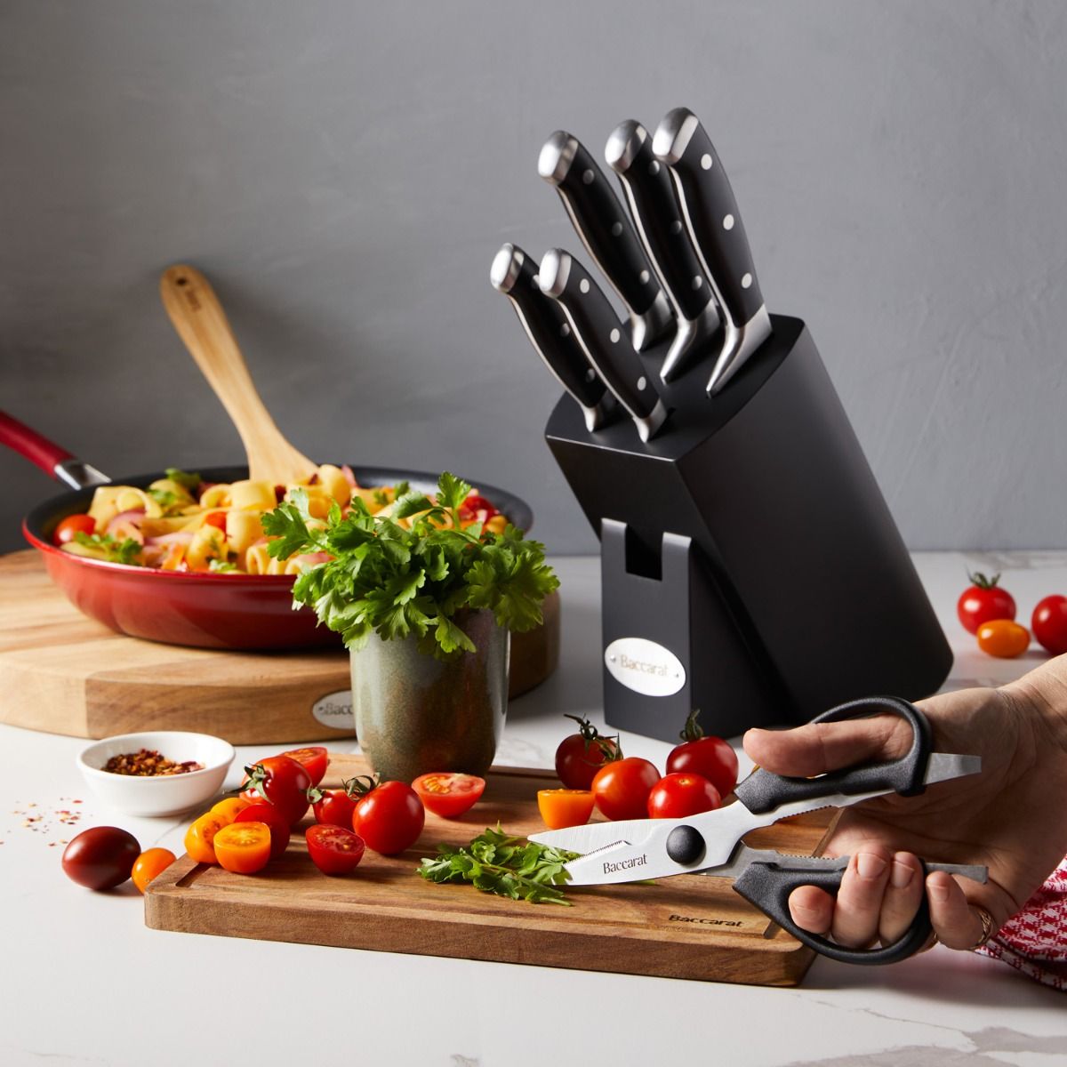 Top view of Baccarat Artisan Finster kitchen knives featuring sleek black handles on a wooden board