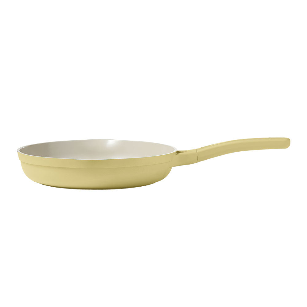 A light yellow non-stick frying pan with a long handle, shown from a side angle against a plain white background.