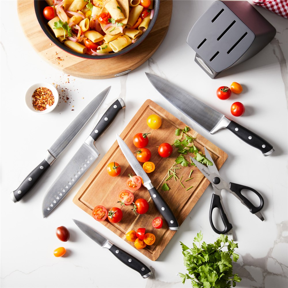 Top view of Baccarat Artisan Finster kitchen knives featuring sleek black handles on a wooden board