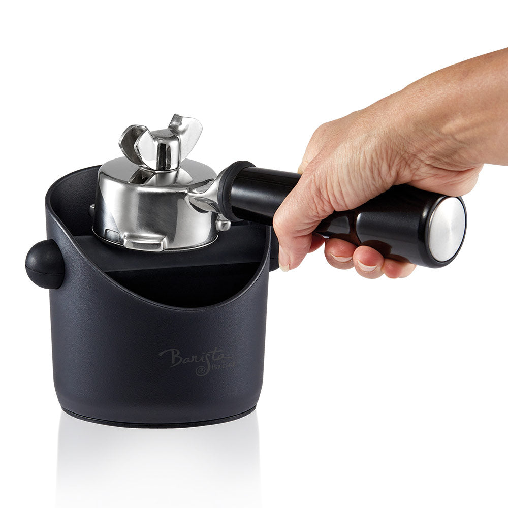metal portafilter tapping coffee grounds into black knock box - Baccarat id3 Samurai cleaver 17 5cm