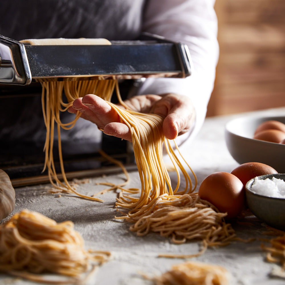 Fresh pasta and flour with a pasta maker on a gray background chrome pasta machine 180mm - Baccarat