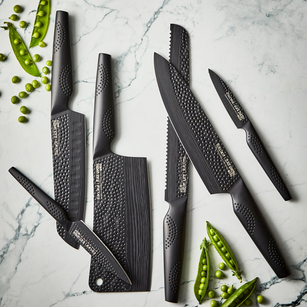 Sharp Black Samurai chef's knife on wooden surface with dried herbs and mushrooms - Baccarat ID3 