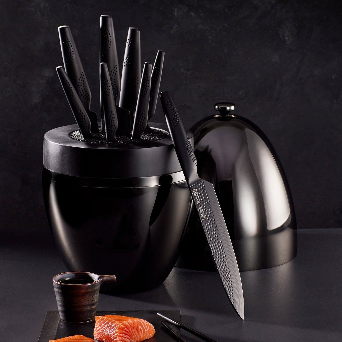 A top-angle view of sleek black knives with precision blades arranged vertically - Baccarat Samurai