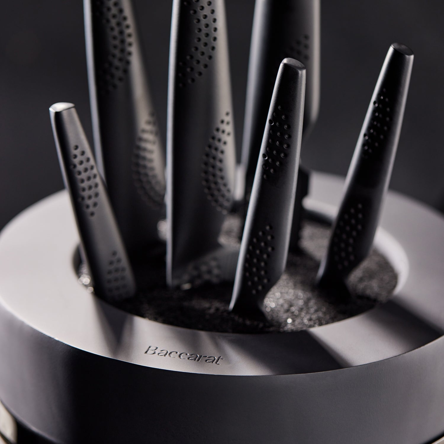 A top-angle view of sleek black knives with precision blades arranged vertically - Baccarat Samurai