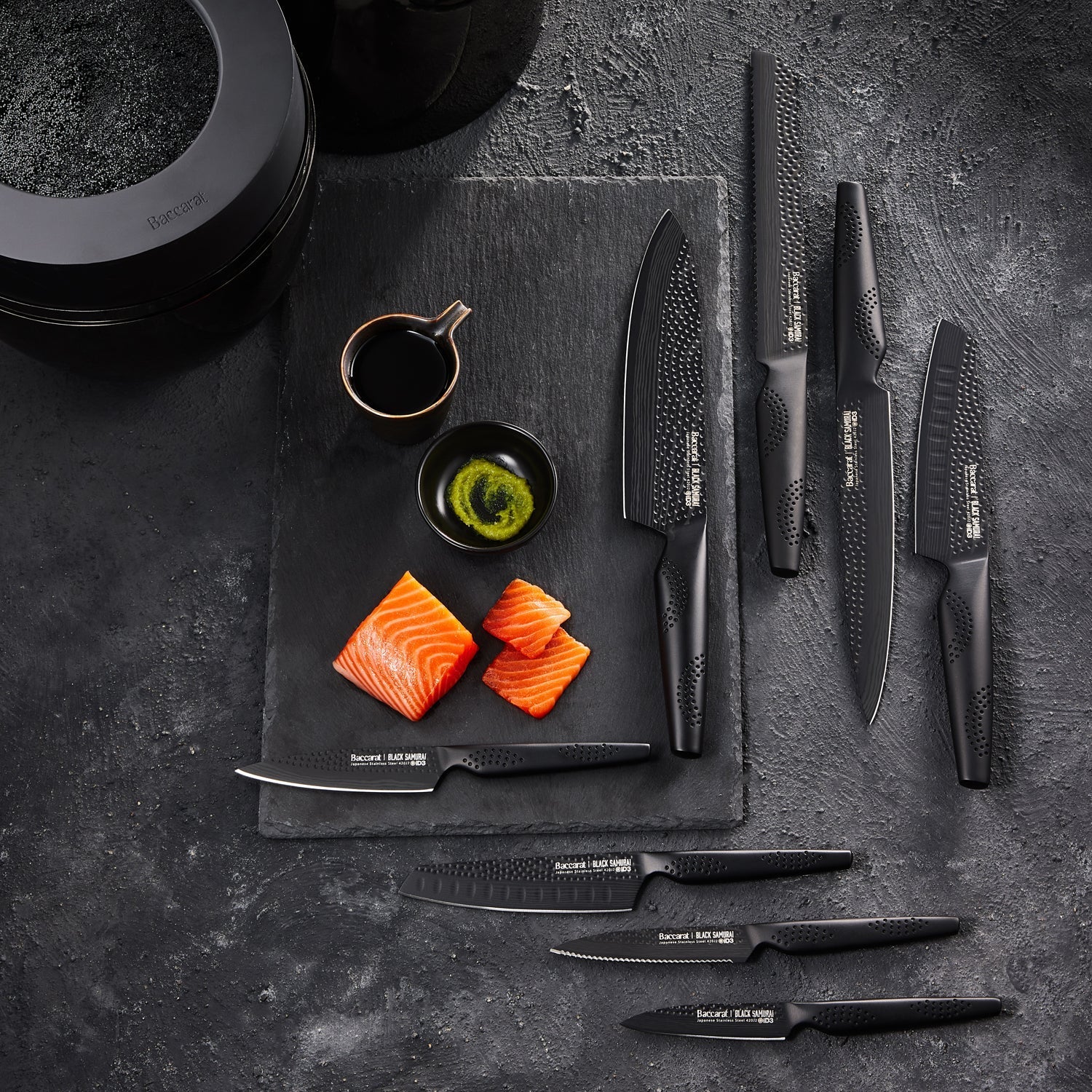 A top-angle view of sleek black knives with precision blades arranged vertically - Baccarat Samurai
