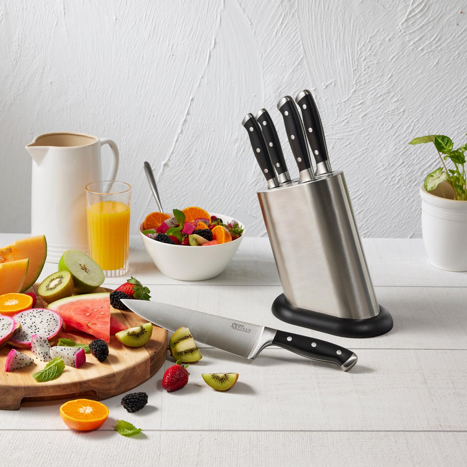 Wooden cutting board with fresh veggies and fruits and sleek black knives - Baccarat Artisan Stahl