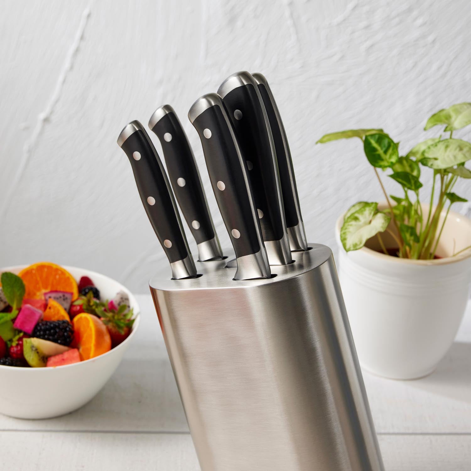 Wooden cutting board with fresh veggies and fruits and sleek black knives - Baccarat Artisan Stahl