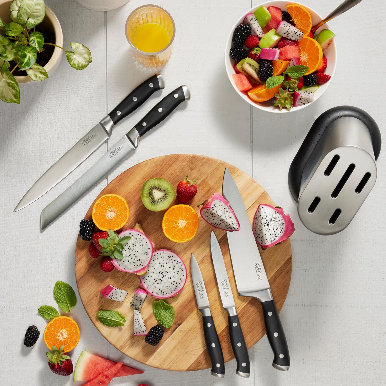 Wooden cutting board with fresh veggies and fruits and sleek black knives - Baccarat Artisan Stahl