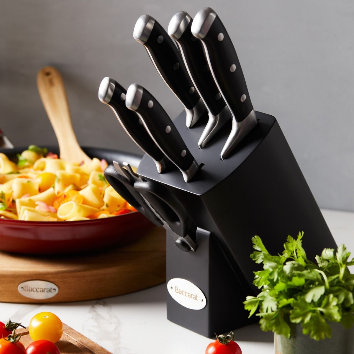 Top view of Baccarat Artisan Finster kitchen knives featuring sleek black handles on a wooden board