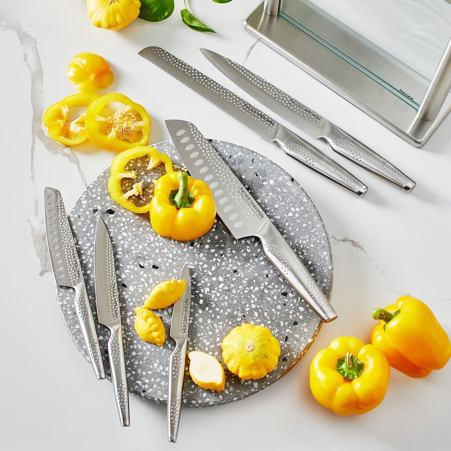 A polished knife block set with sharp blades and sleek design next to fresh vegetables - Baccarat