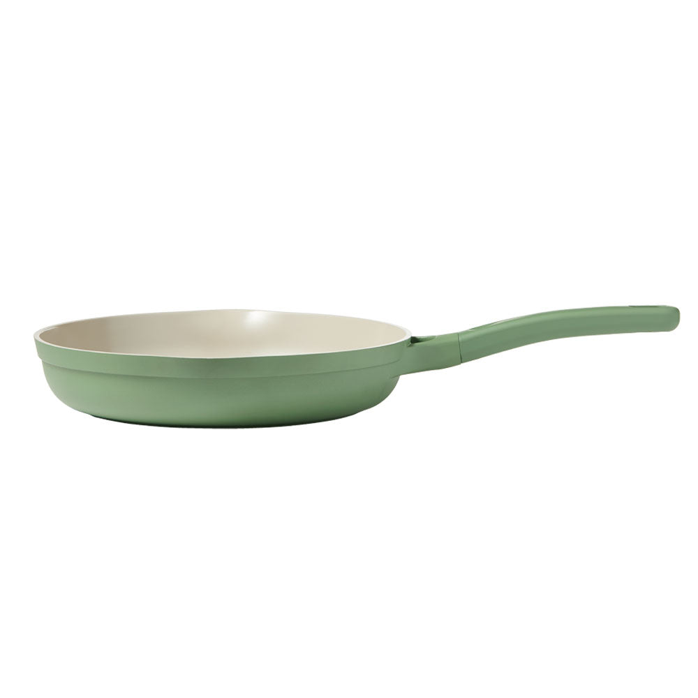 A sage green non-stick frying pan with a cream-colored interior and a matching sage green handle, shown against a plain white background.