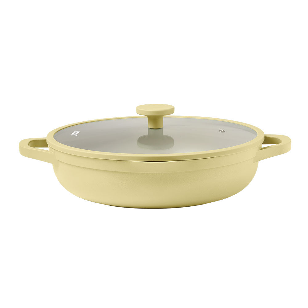 Yellow cookware with a glass lid on a white background