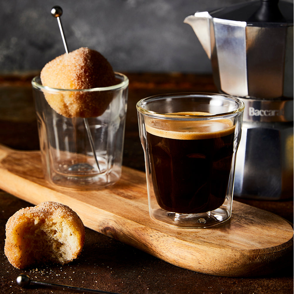 Steaming espresso in double wall glass on wooden board with biscotti - Baccarat Barista Facet