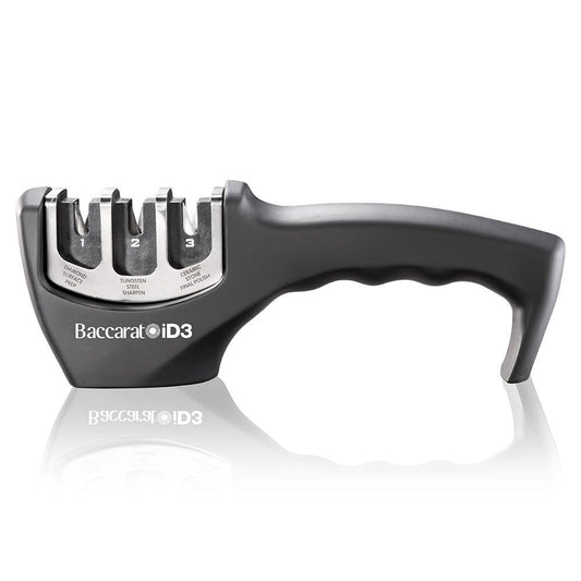 A person sharpens a large knife on a kitchen counter beside fruits- Baccarat 3-Step Knife Sharpener