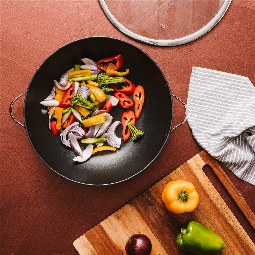A vibrant array of sliced vegetables in a non stick wok with lid - Baccarat id3 hard anodised 36cm