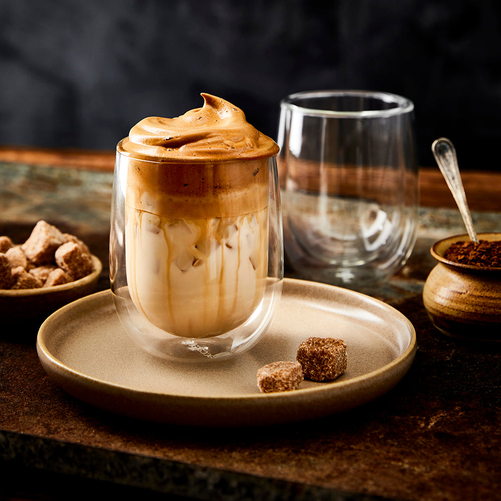 Salt keeper on a rustic beige plate with brown sugar cubes and iced coffee - Baccarat spice market