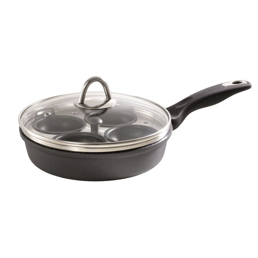 A sleek egg poacher with four sections surrounded by fresh eggs and greens - Baccarat granite