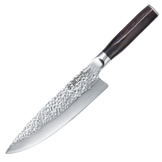 A stunning Baccarat Damashiro Emperor 15 cm chef's knife on a dark cutting board with green veggies