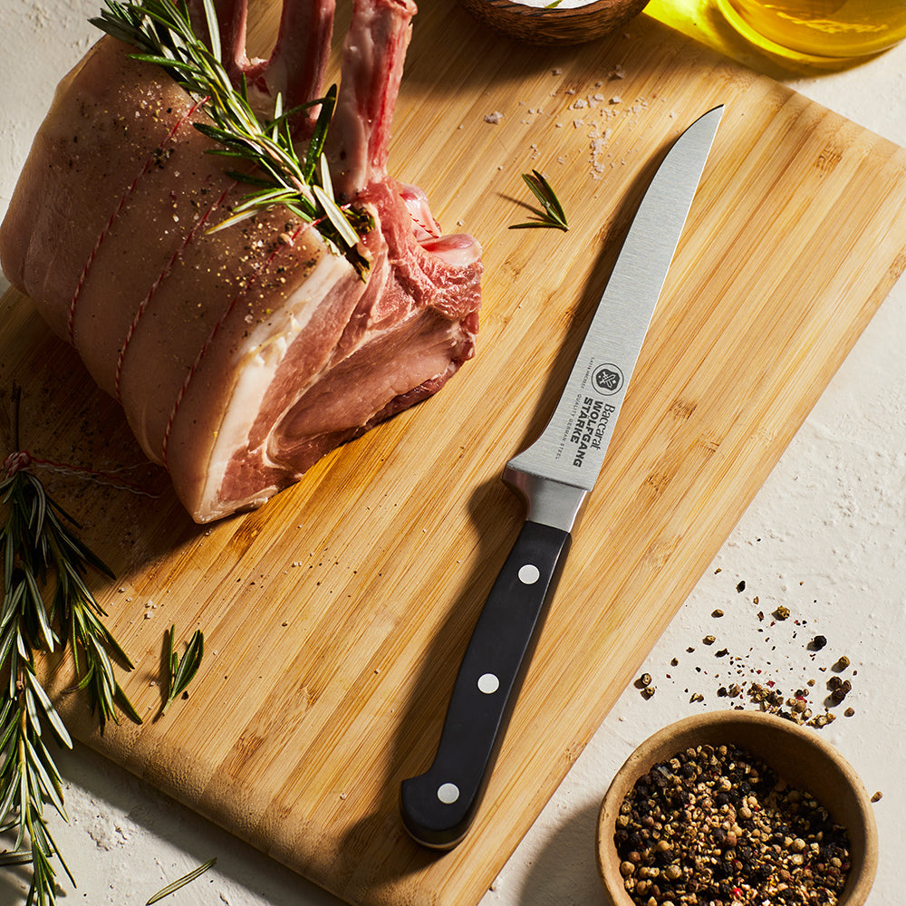Wolfgang Starke stainless boning knife surrounded by figs and herbs on a grey surface - Baccarat 