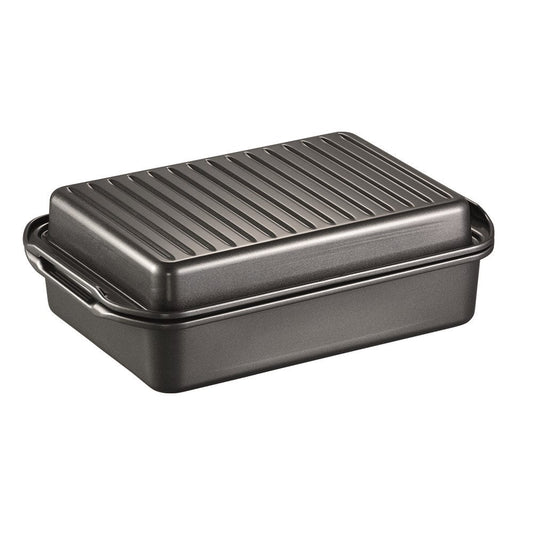 A baked dish in a grill on a wooden board garnished with herbs - Baccarat Carbon Steel Roast Grill