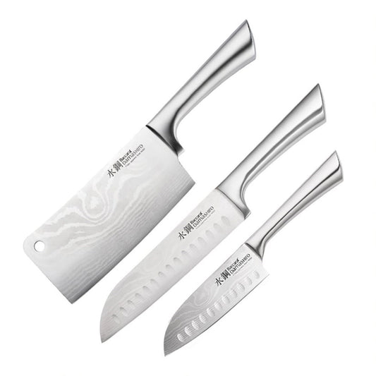Three stainless steel knives next to whole and sliced limes grey surface - Baccarat Damashiro