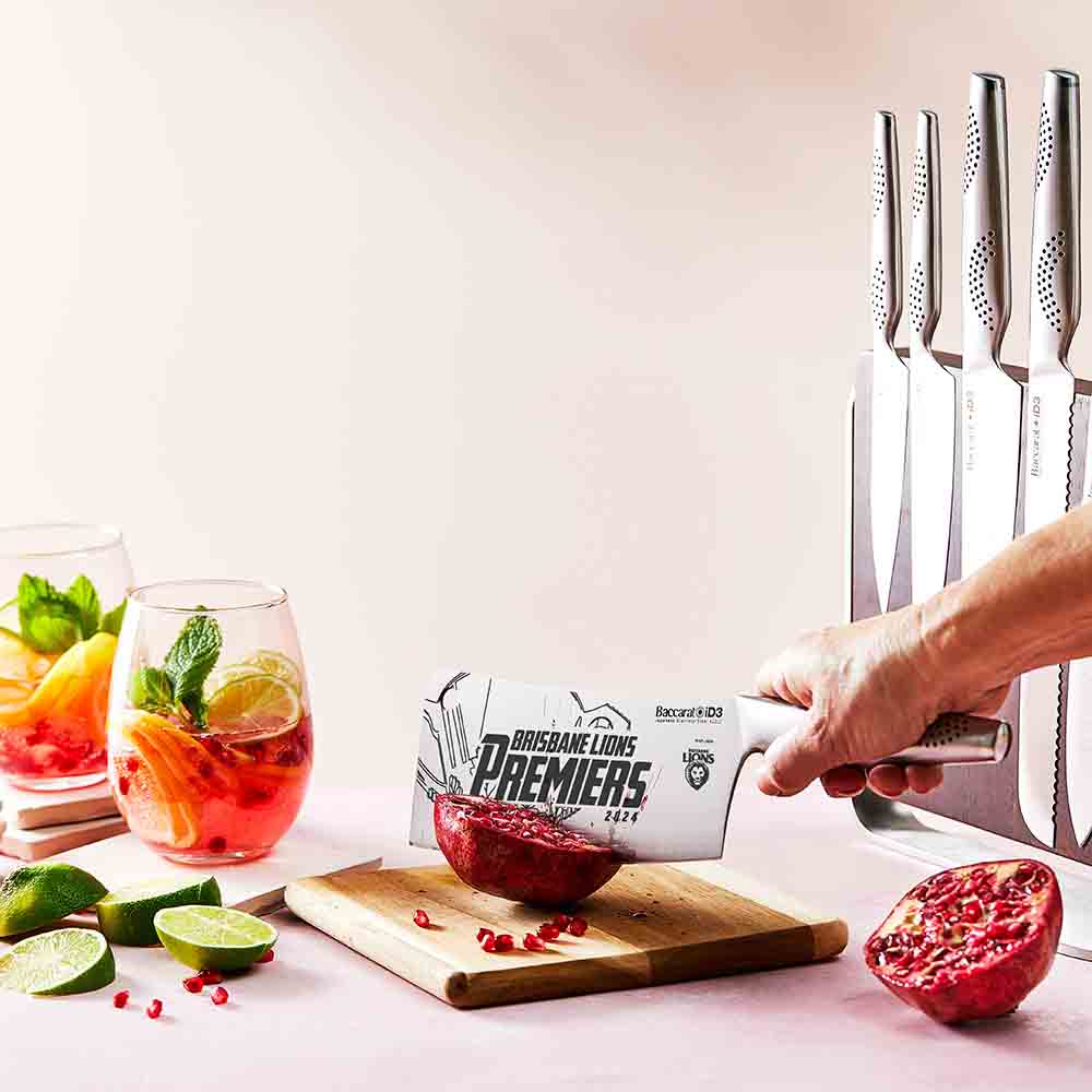 Sharp stainless steel kitchen knives with lime slices and cocktails on a pink surface - Baccarat