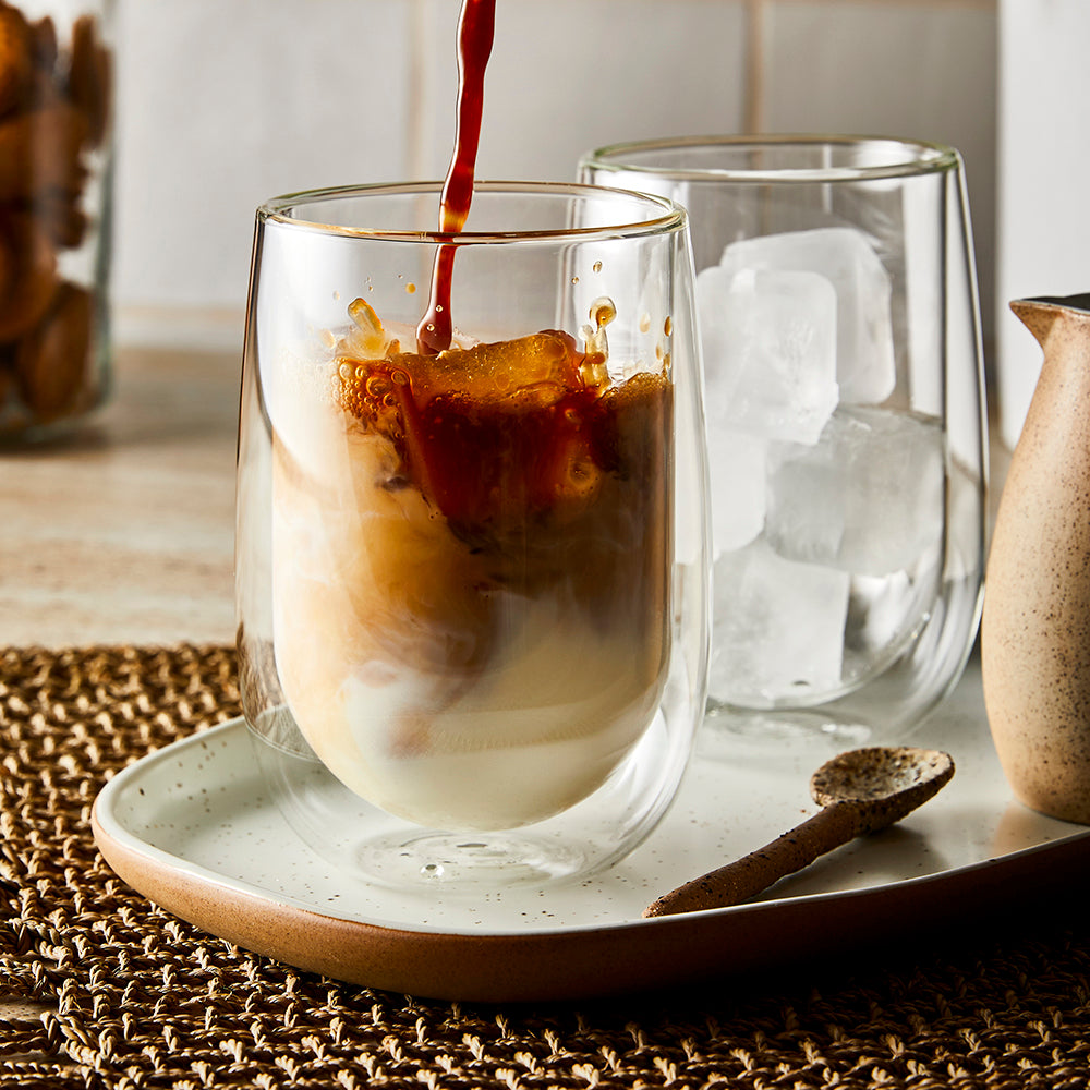 Two double wall thermal glass tumblers filled with creamy cappuccino brown color - Baccarat