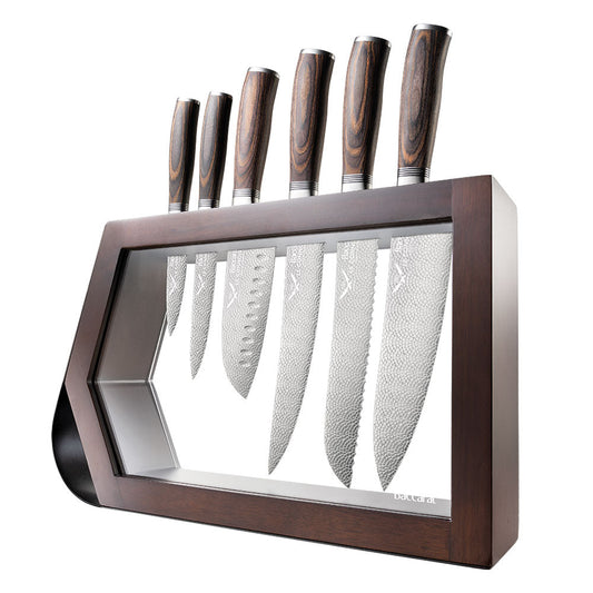 Chef's knife slicing garlic on a kitchen counter shiny silver blade 7 piece knife block - Baccarat