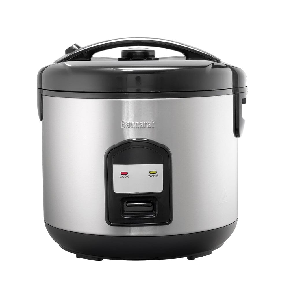 A person opening a silver rice cooker on a kitchen counter next to a bowl of veggies- Baccarat