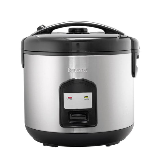A person opening a silver rice cooker on a kitchen counter next to a bowl of veggies- Baccarat