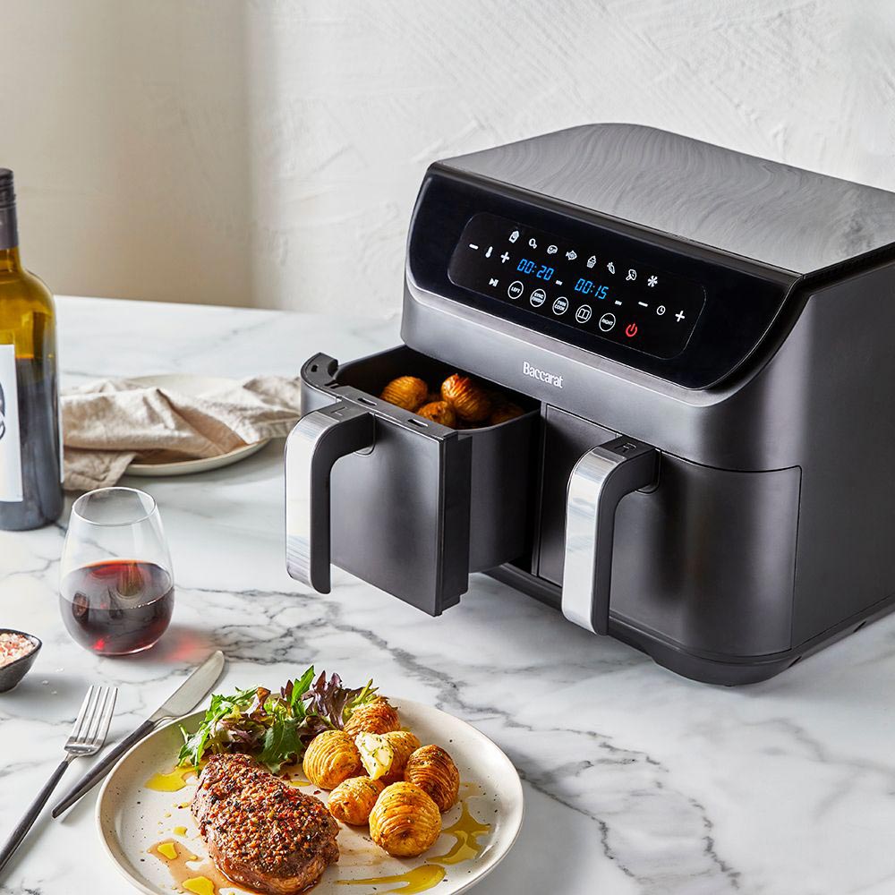 Close-up of a sleek black loaf bread maker with removable baskets and cooked potatoes - Baccarat