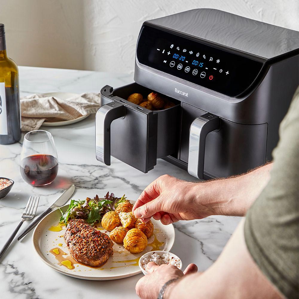 Close-up of a sleek black loaf bread maker with removable baskets and cooked potatoes - Baccarat