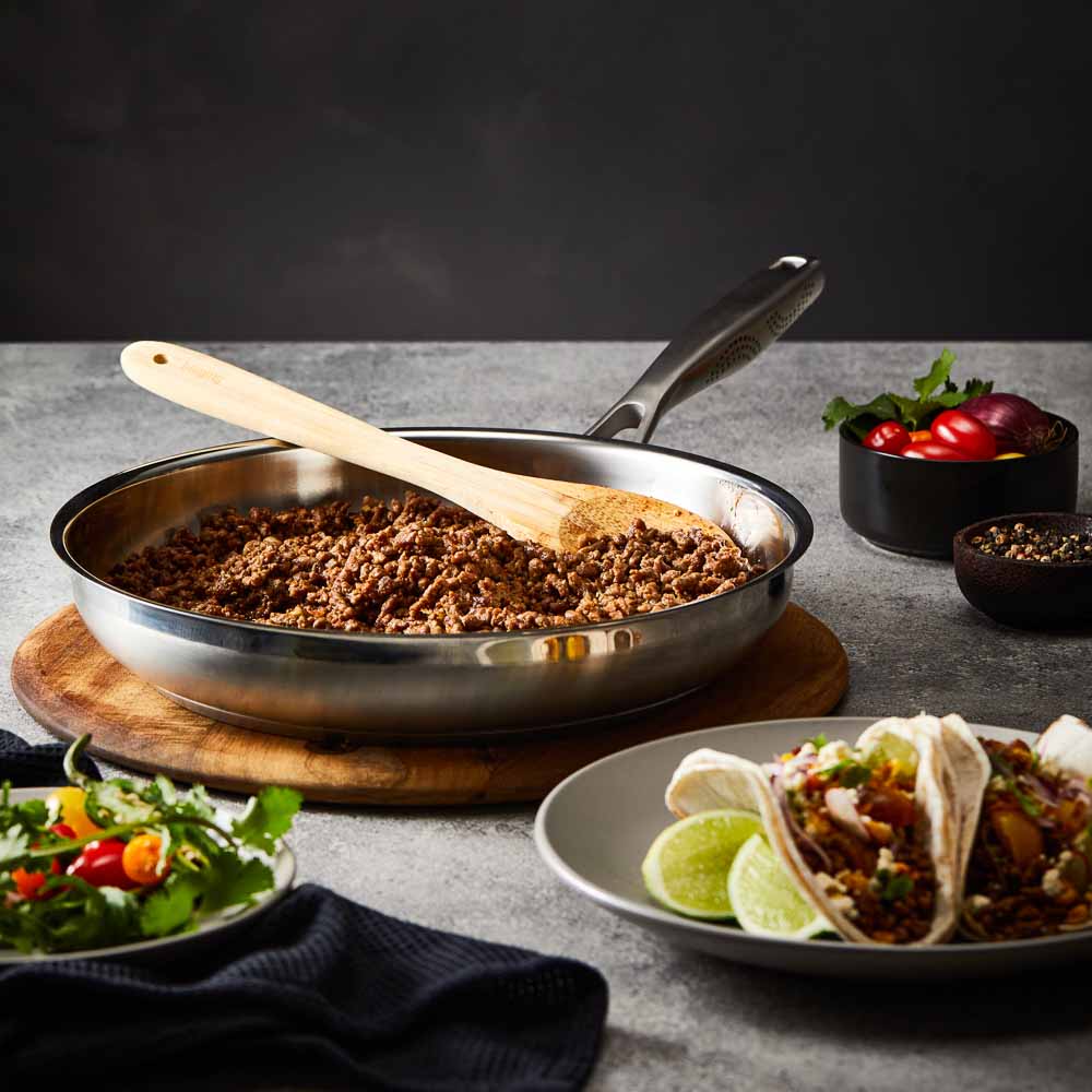 Baccarat id3 Stainless Steel 30cm Frypan with cooked ground beef on a table with tacos and salad