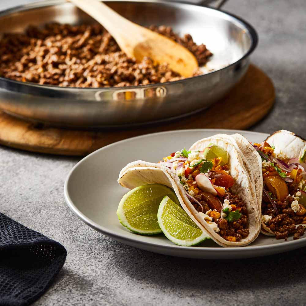 Baccarat id3 Stainless Steel 30cm Frypan with cooked ground beef on a table with tacos and salad