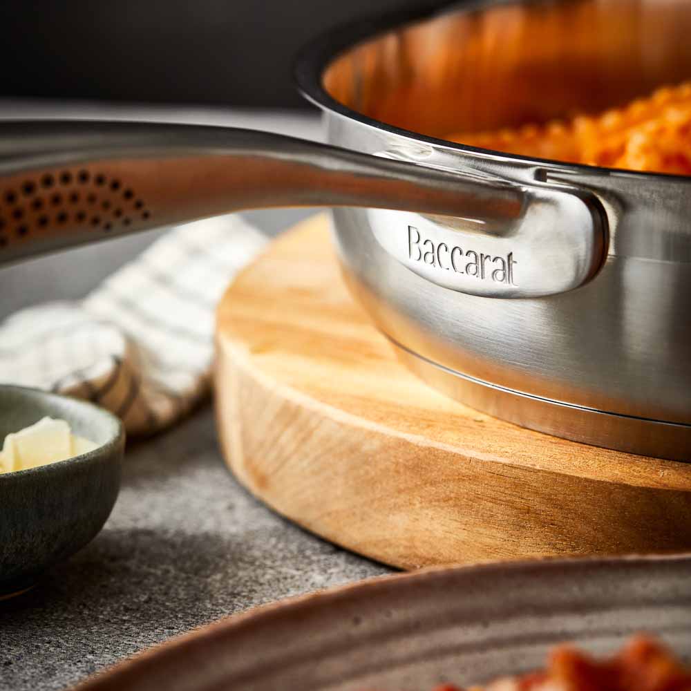 Close-up of a Baccarat id3 Saute Pan 28cm frypan with a glass lid and steam featuring silver handle