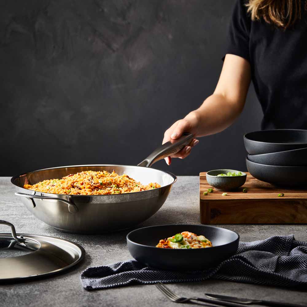 Person serving gourmet pasta from a black bowl - Baccarat id3 stainless steel chef pan with lid 32cm