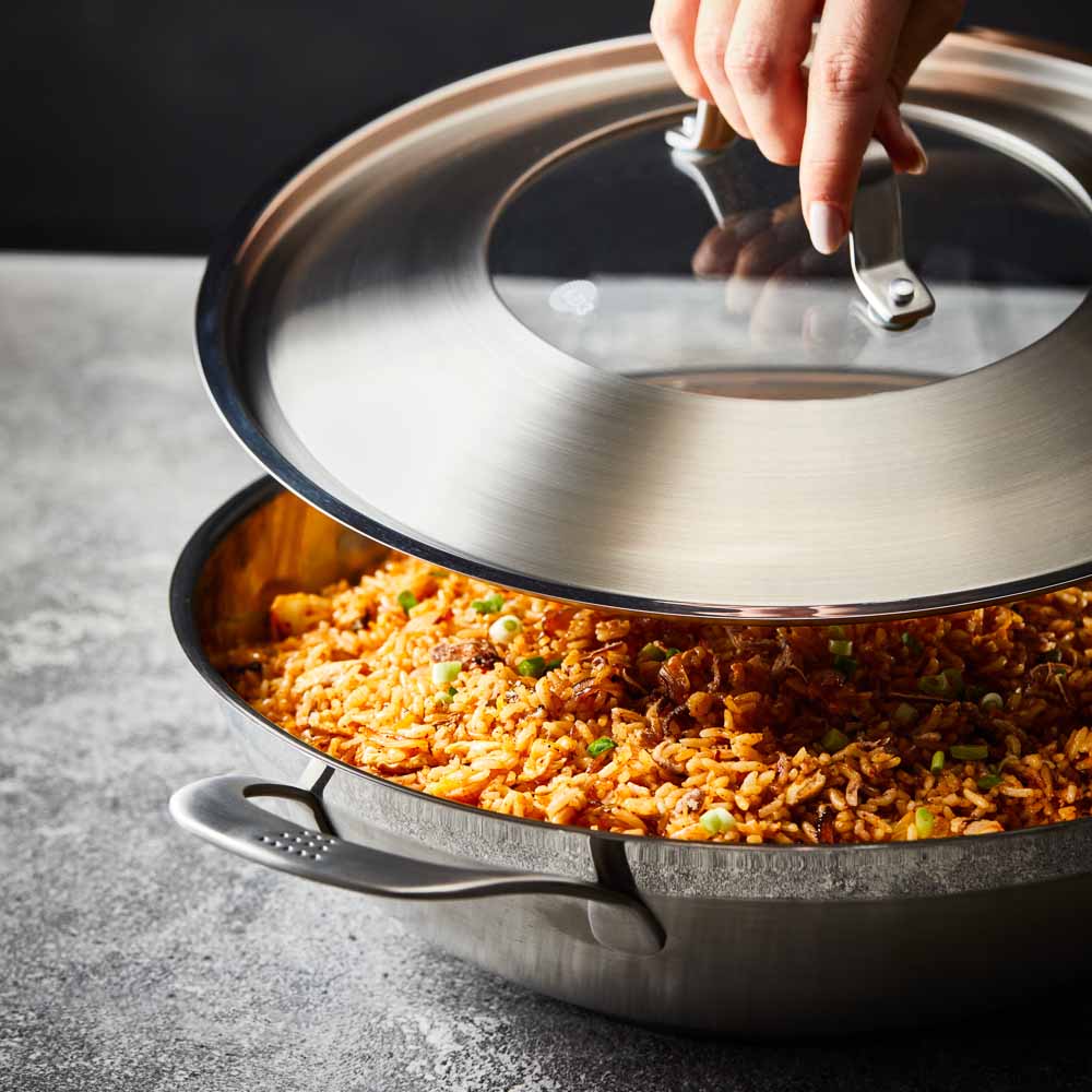 Person serving gourmet pasta from a black bowl - Baccarat id3 stainless steel chef pan with lid 32cm