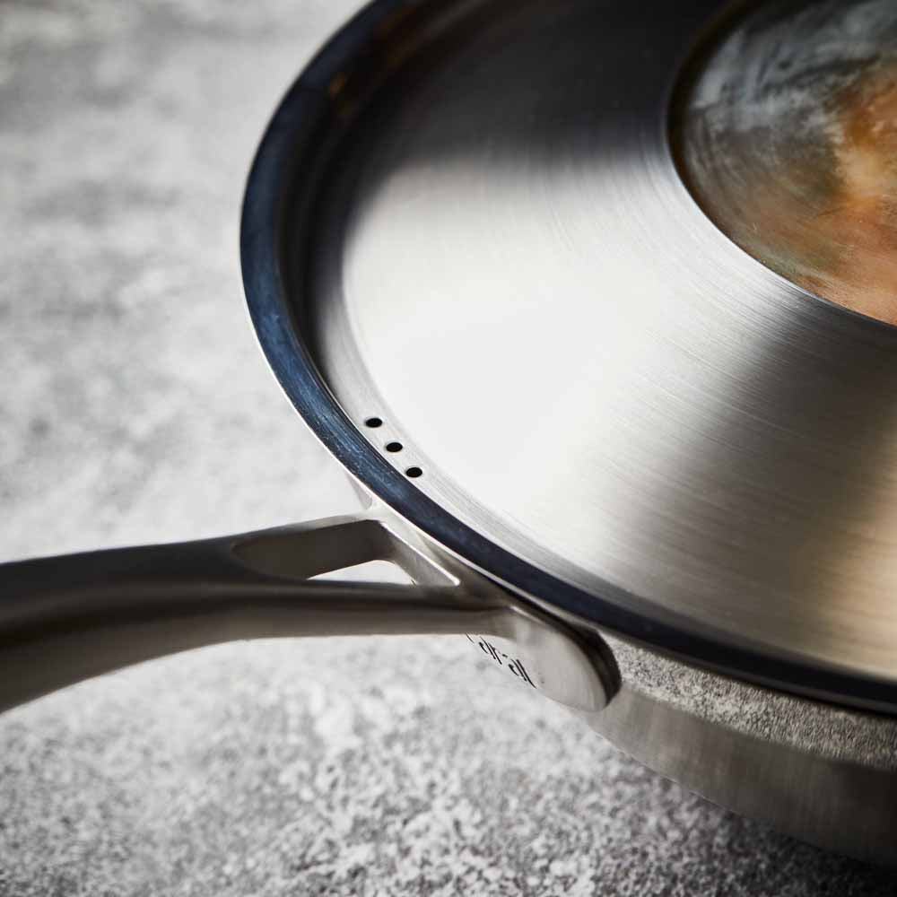 Person serving gourmet pasta from a black bowl - Baccarat id3 stainless steel chef pan with lid 32cm