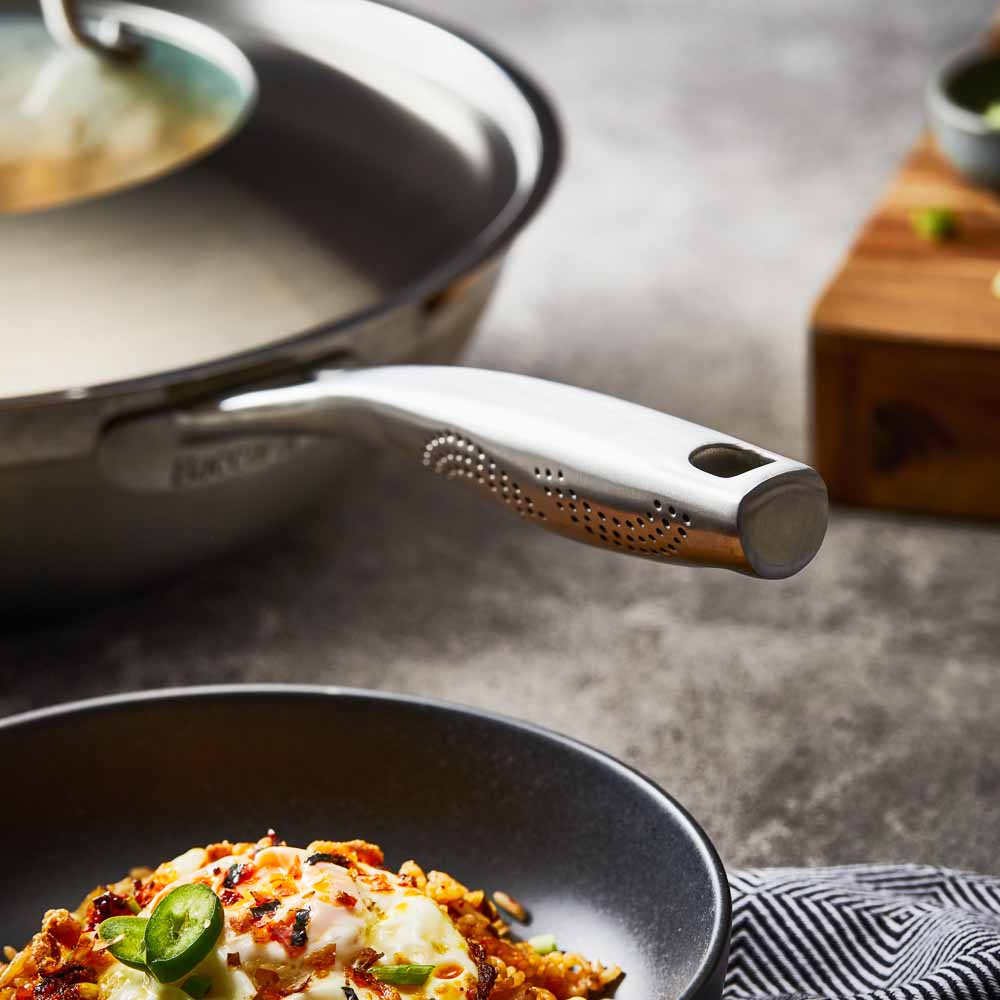 Person serving gourmet pasta from a black bowl - Baccarat id3 stainless steel chef pan with lid 32cm
