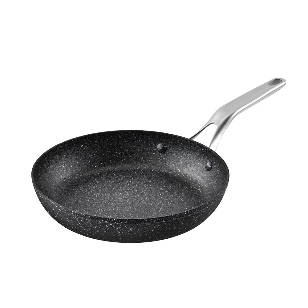 Black speckled frying pan with a silver handle on a white background