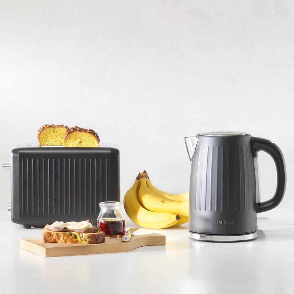 Black kettle pours hot water into a white cup beside a pastry plate - Baccarat  Boiling Point Kettle