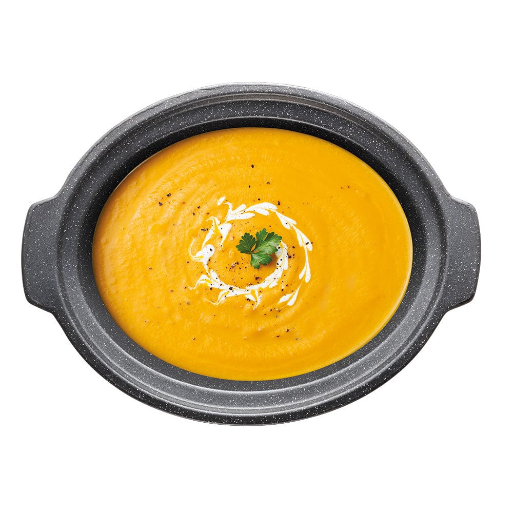 A vibrant orange creamy soup garnished with fresh parsley in a sleek bowl - Baccarat the Tasty Chef