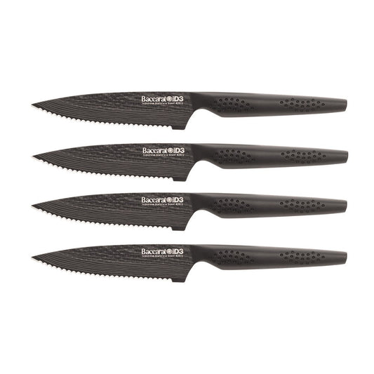 Elegant Baccarat Samurai Set of 4-piece steak knives lined up on dark slate with herbs and spices